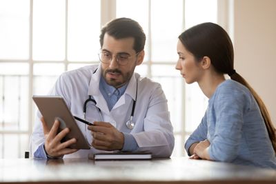 a doctor and a patient looking at a tablet