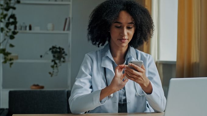 A doctor searching for information and knowledge management on her phone.