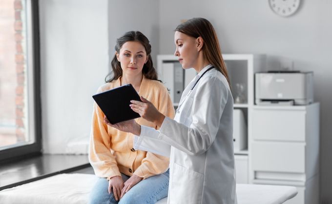 A female doctor explaining the safety benefits of health IT to a patient.