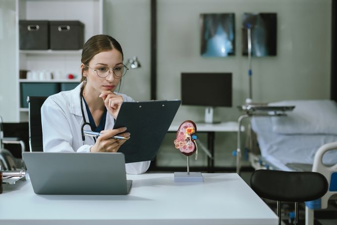 A doctor taking notes on information and knowledge management while sitting in an office.