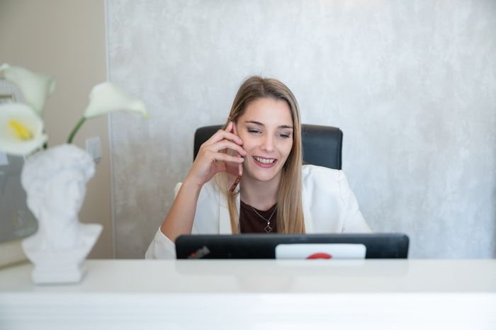 A female doctor discussing turnover rates over a phonecall.