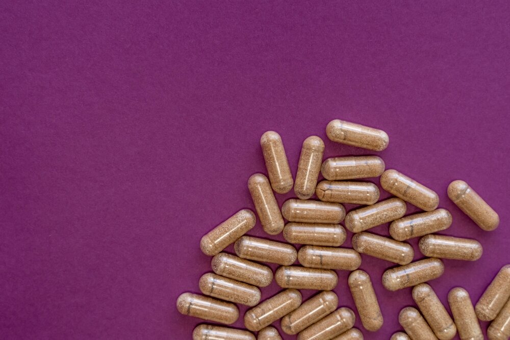 Brown capsules scattered against mauve background.