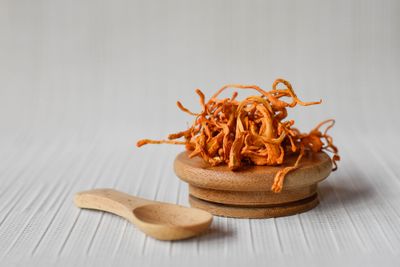Cordyceps Militaris harvested and resting on wooden spoon and plate
