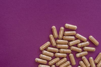 Brown capsules scattered against mauve background.