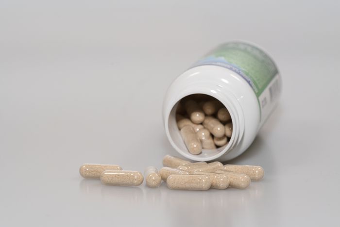 Lion's Mane capsules being emptied out of a jar to be dosed correctly