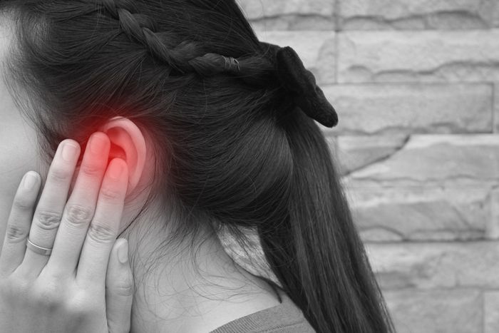 Woman rubbing her ears in pain due to tinnitus