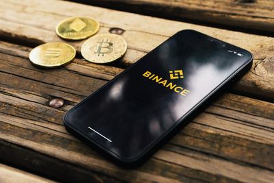 A smartphone laying on a table displaying the Binance logo