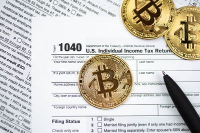 Golden coins scattered on top of US 1040 form for tax return, along with other papers.