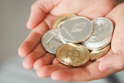 Various cryptocurrencies held in a person's cupped hands