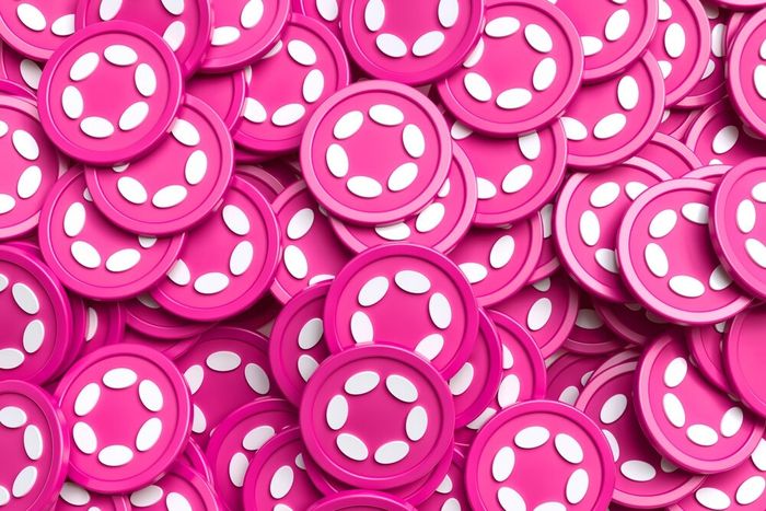 A bunch of bright pink Polkadot coins laying in a pile.