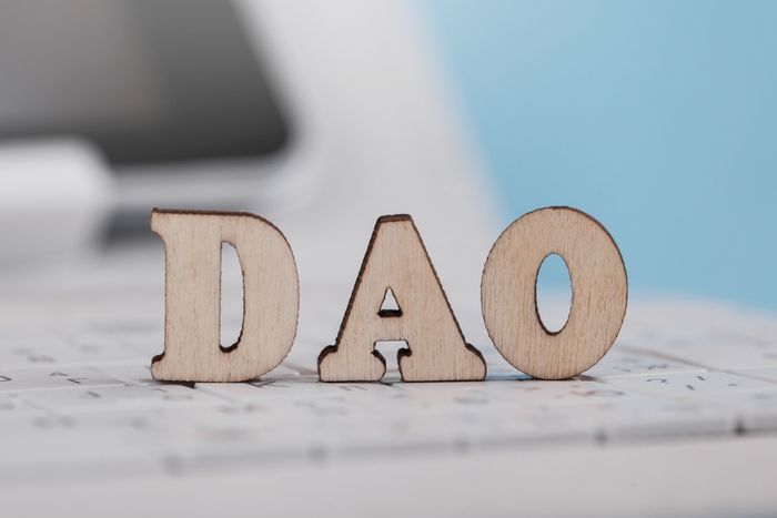 Wooden letters spelling 'DAO' on a keyboard background