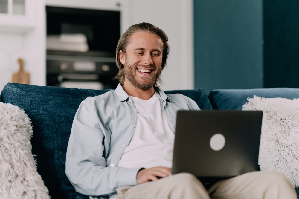 Man sitting on the couch using a laptop