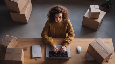 a woman sitting at a table working on a laptop