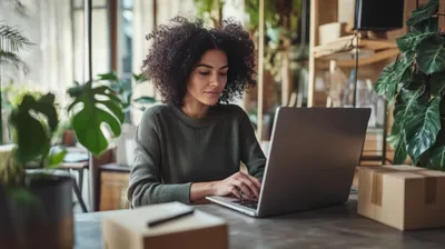 a woman sitting at a table using a laptop 