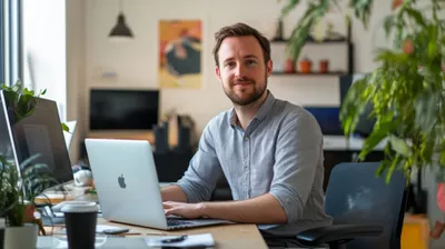 a man sitting in front of a laptop 