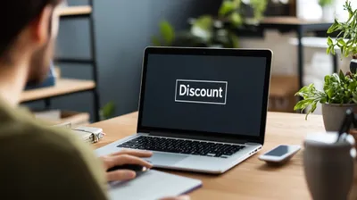 a man sitting in front of a laptop the word discount is visible on the screen
