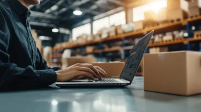 a man working on a laptop in a warehouse
