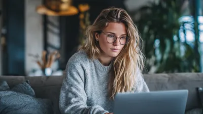 a woman sitting on a couch using a laptop computer