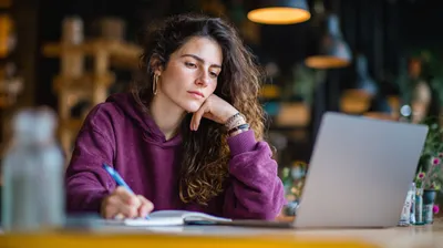 a woman sitting in front of a laptop computer