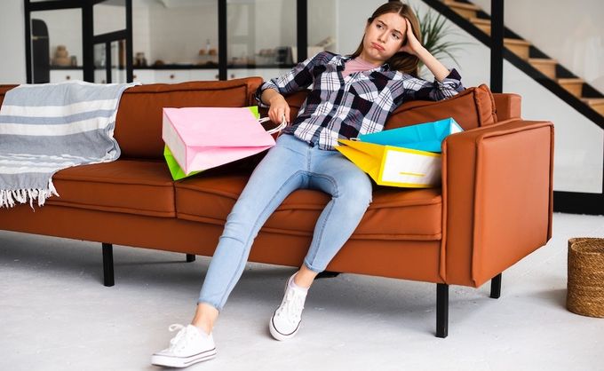 a woman sitting on a couch with shopping bags