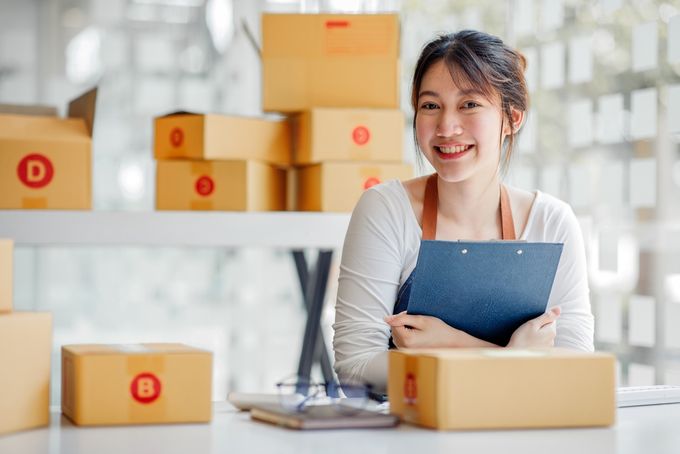 Woman holding a clipboard surrounded by small boxes