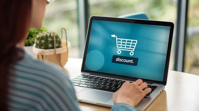 a woman sitting in front of a laptop, with the word discount visible