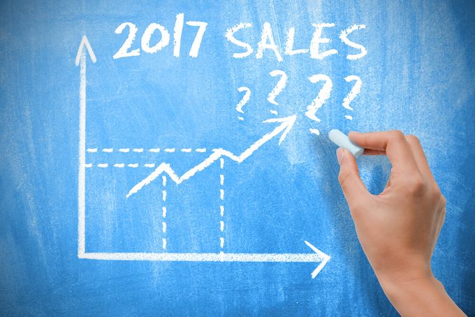 Hand writing a Shopify sales forecasting graph on a chalkboard