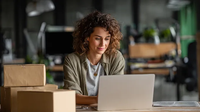 a woman sitting in front of a laptop 