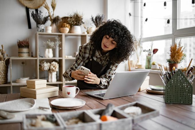 A business woman taking photos so she can upload product images to Shopify.
