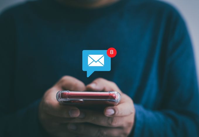 eCommerce customer holding a cell phone with receiving a back-in-stock email notification