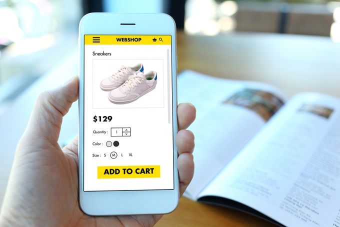 a person holding a cell phone with a Shopify store image