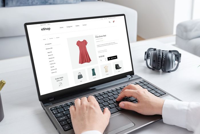 eCommerce store owner using a laptop computer on a table reviewing their product variants for a dress