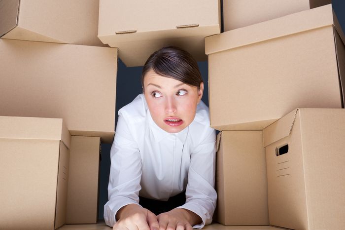 Stressed Shopify store owner surrounded by boxes and too many products