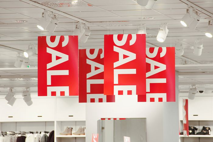 Red sale signs hanging from the ceiling of a store