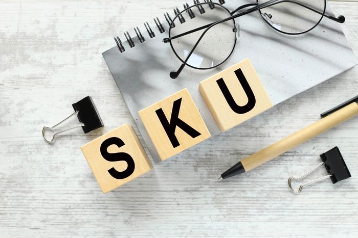 Wooden blocks that say "SKU" next to a pair of glasses