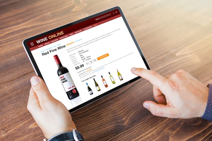 a person pointing at a wine bottle on a tablet