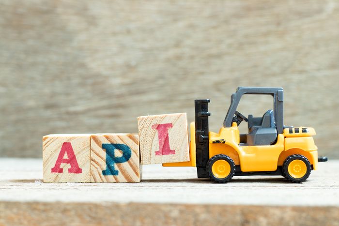 A yellow toy forklift with blocks spelling 'APR'