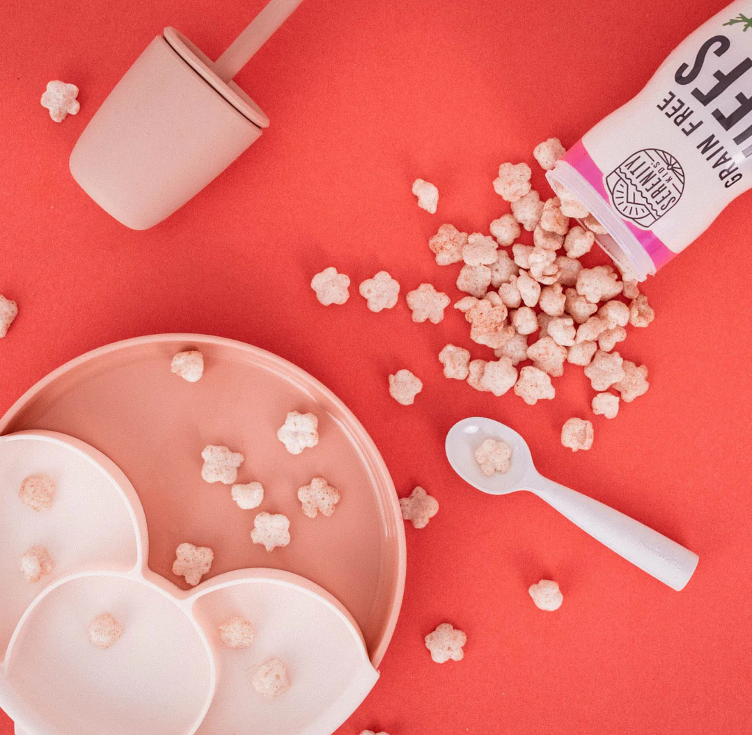 a bowl of popcorn next to a cup of milk