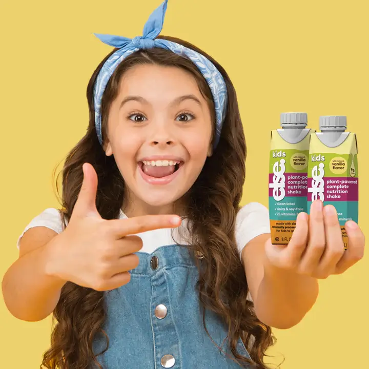 a young girl holding two bottles of juice