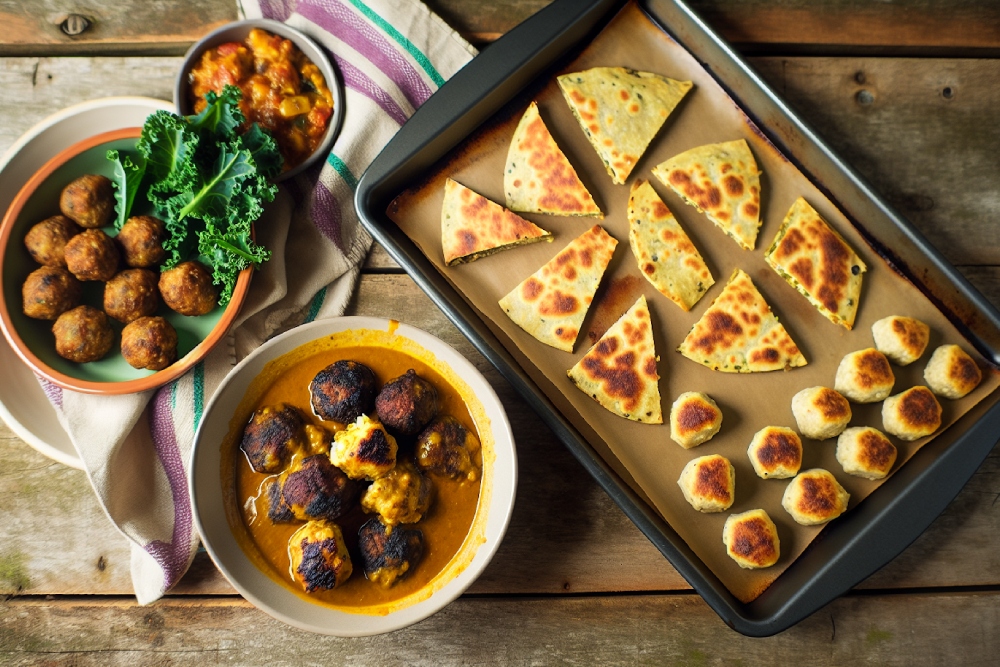 a table topped with bowls of food next to a pan of food