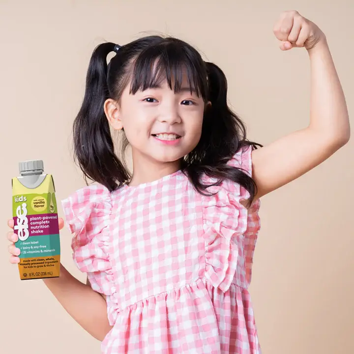 a little girl holding a carton of juice