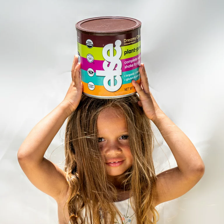 a little girl holding a can of food on her head