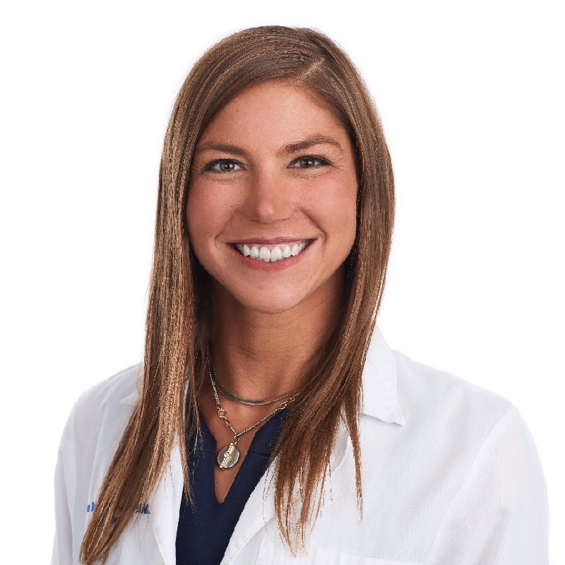 a woman with long hair wearing a white lab coat