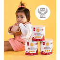 a little girl sitting on the floor with four cans of baby formulas