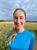 a woman in a blue shirt standing in a field