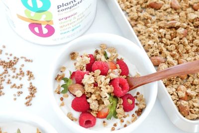 a bowl of granola next to a container of yogurt