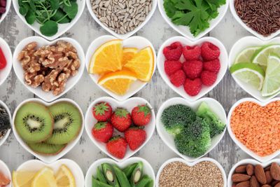 a variety of fruits and vegetables arranged in heart shaped bowls