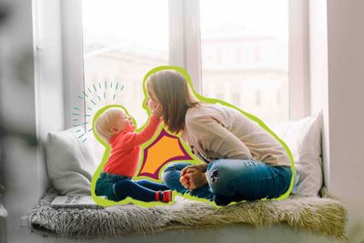 a woman sitting on a window sill next to a baby