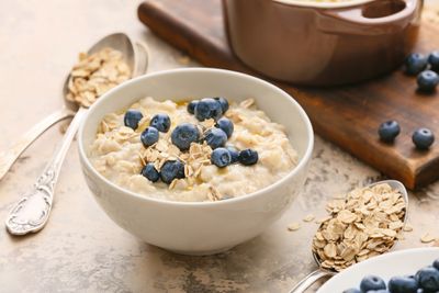 A bowl of oatmeal with blueberries and granola which is a food high in carbohydrates.