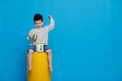 a young boy sitting on top of a yellow object